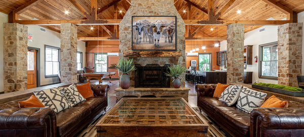 A western art print of Texas Longhorns cattle along the Chisholm trail from the Stockyards, against a dusty trail background. An oil painting by wildlife artist James Corwin. Hanging in living room home decor wall art.