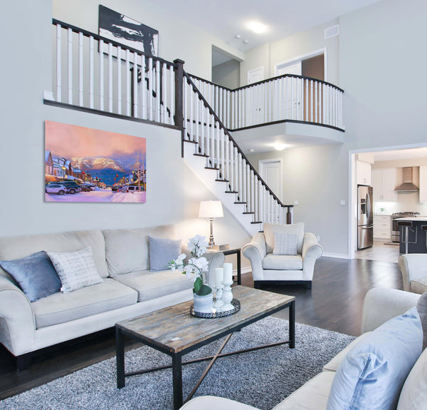 A canvas print depicting big mountain whitefish mountain resort in a snowy downtown scene at sunset under Christmas lights. Whitefish Montana painting by wildlife artist James Corwin. Hanging in living room wall art home decor.