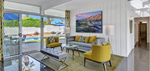 A canvas print painting featuring a realistic depiction of a coyote in a desert wildflower field during sunset by wildlife artist James Corwin. Hanging in living room wall decor.