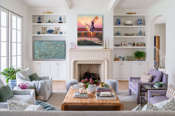A canvas print from an oil painting featuring a dancing sandhill crane in mid-flight against a backdrop of a setting sun and a full moon in a colorful wetland. Wildlife art by James Corwin artist. Hanging in living room wall art home decor.